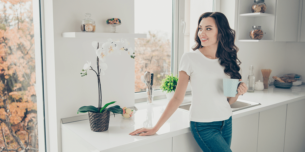 Home Air Filter Thanks to a home air filter, a pretty homeowner enjoys clean air and a coffee in her clean kitchen.