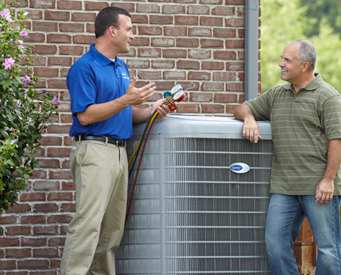 HVAC tech meets with homeowner in his backyard to install a new air conditioner.
