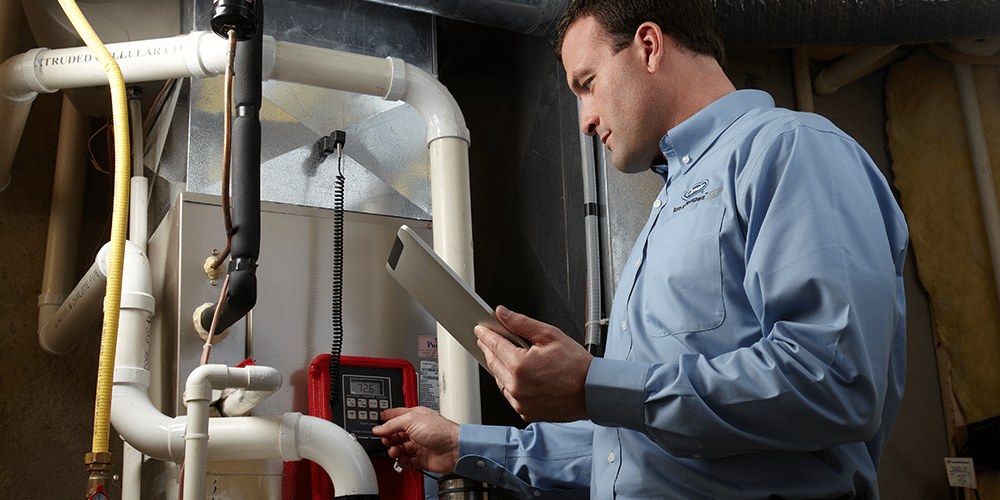 Tech in blue shirt performs furnace troubleshooting steps after being called in for help.