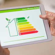 Homeowner holds tablet to see results after improving energy efficiency.