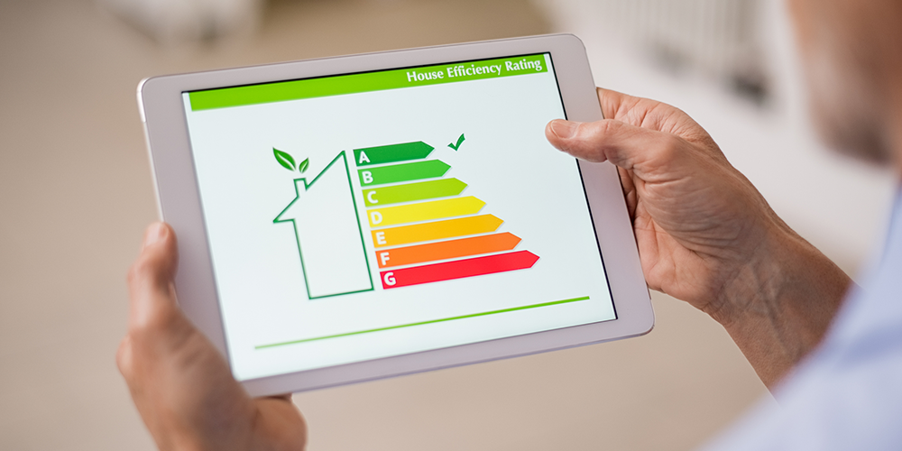 Homeowner holds tablet to see results after improving energy efficiency.