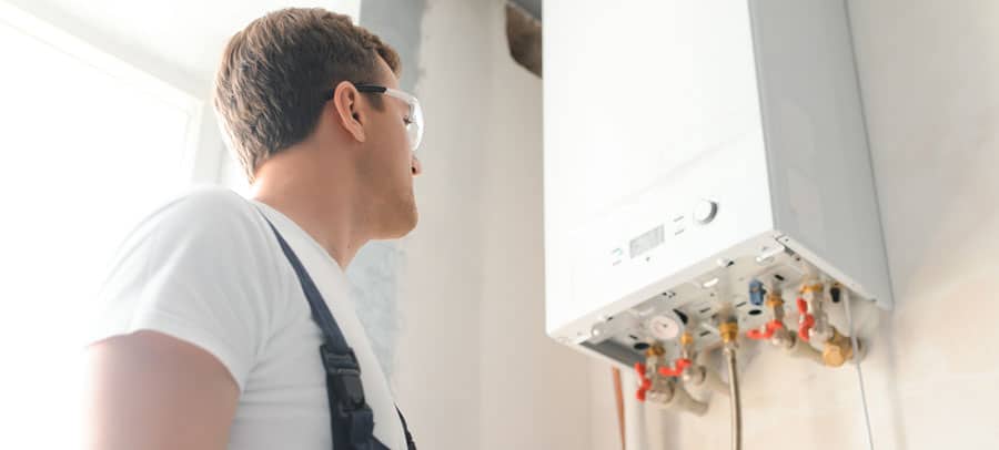 Boiler Maintenance Tech in white shirt and safety goggles performs boiler maintenance on a customer’s unit.
