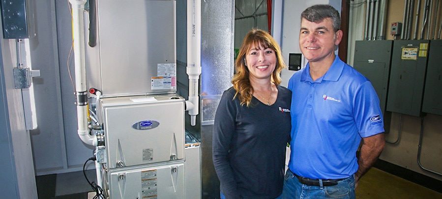 Furnace Installation RJ owners Julius and Erin pose with a Carrier furnace in their technician’s ongoing training lab.